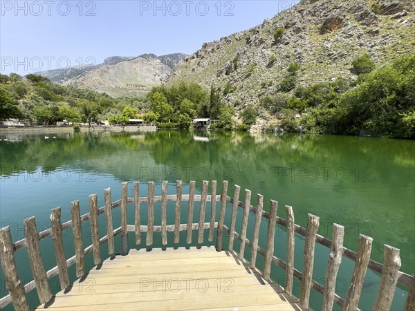 View of the small viewing platform at the front of an artificial lake created in 1987 on the edge of the Psiloritis Mountains and fed by the Votomos spring Votomos Lake Votomos Zaros Lake Zaros Lake Zaros Lake, in the background foothills of the Psiloritis Mountains Psiloritis Massif Ida Mountains, Zaros, Crete, Greece, Europe