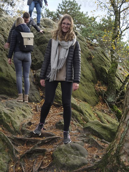 A woman enjoying autumn hiking over rocky terrain with friends, Tecklenburg, North Rhine-Westphalia, Germany, Europe