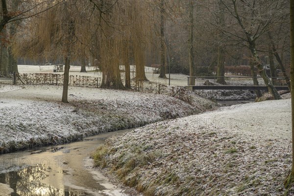 Frost-covered trees and grass surround a small river with a bridge in a wintry park, Velen, North Rhine-Westphalia, GERMANY