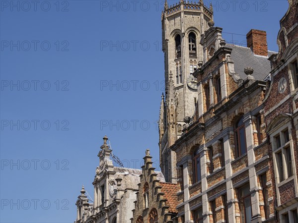 Historic buildings and tower with detailed architecture under a blue sky, Bruges, Belgium, Europe