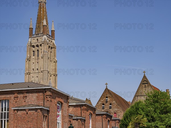 Historic church with high stone towers, framed by a clear summer sky, Bruges, Belgium, Europe