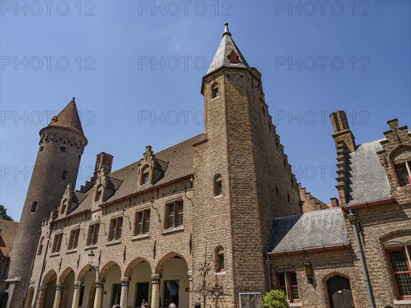A medieval castle with high towers and an archway, Bruges, Belgium, Europe