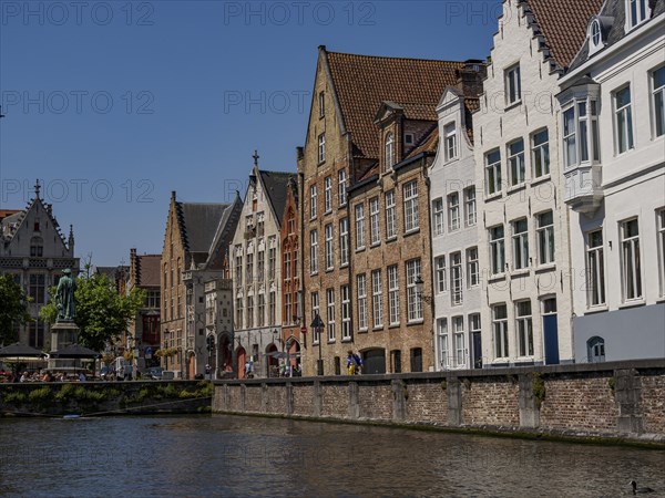 A row of historic buildings along a canal in sunny weather, Bruges, Belgium, Europe