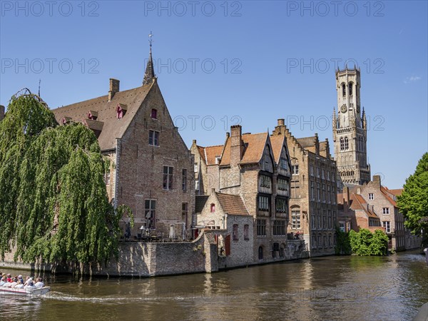 A picturesque canal with boats, surrounded by historic brick buildings and nature, Bruges, Belgium, Europe