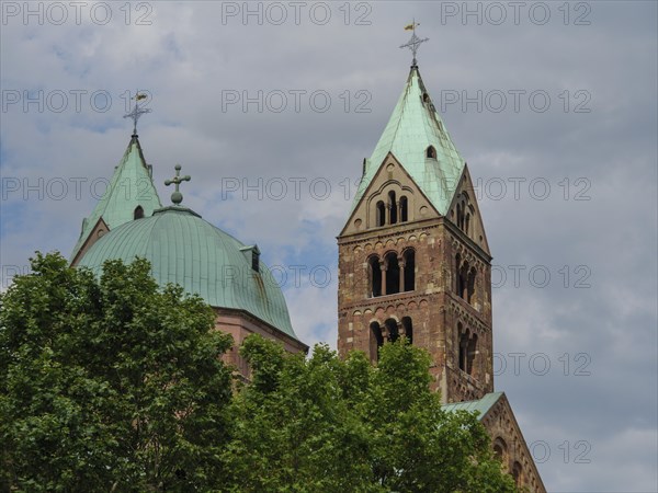Romanesque cathedral with green roofs and striking towers in the background, surrounded by trees, Speyer, Germany, Europe