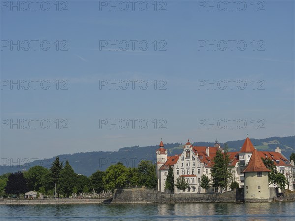 Urban scene with historic buildings and towers along the lakeshore under a clear summer sky, Lindau, Lake Constance, Germany, Europe