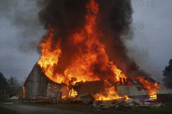 Flames and smoke rise from burning farm building