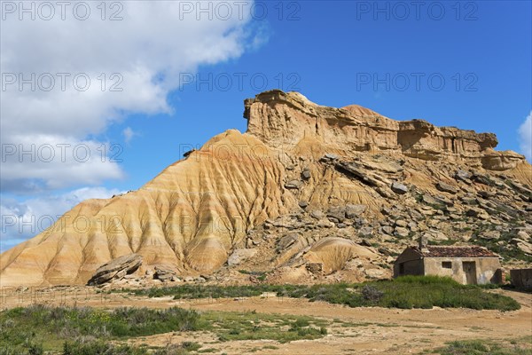 Small hut in front of a striking rocky hill in a desert-like landscape under a blue sky, Bardenas Reales Natural Park, desert, semi-desert, Navarra, Nafarroa, UNESCO Biosphere Reserve, Spain, Europe