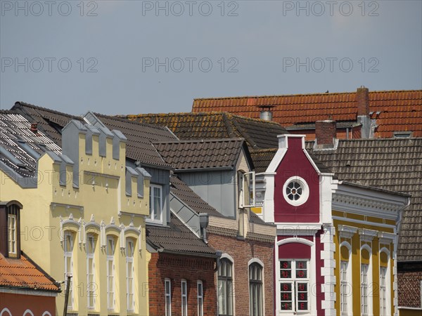 Row of colourful historic buildings with different roof shapes and windows in sunny weather, husum, schleswig-holstein, germany
