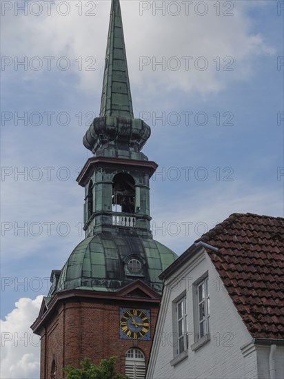 Historic church tower with green roof and clock next to a building, Arnis, Schleswig-Holstein, Germany, Europe