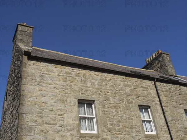 Close-up of a traditional stone house with two fireplaces under a clear blue sky, Lerwick, Shetlands, Scotland, United Kingdom, Europe