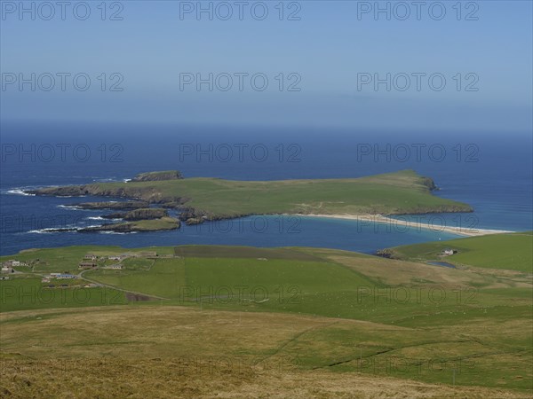 Elevated perspective of an island with a coastline surrounded by green grass and a sandy beach, Lerwick, Shetland, Scotland, United Kingdom, Europe