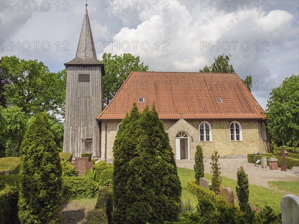 Quiet church with red tiled roof and surrounded by well-tended bushes and trees, Arnis, Schleswig-Holstein, Germany, Europe