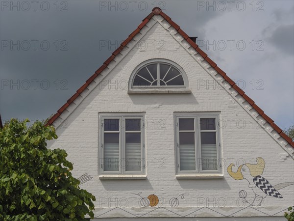 The façade of a house with ornate windows and drawings on the gable wall, Arnis, Schleswig-Holstein, Germany, Europe
