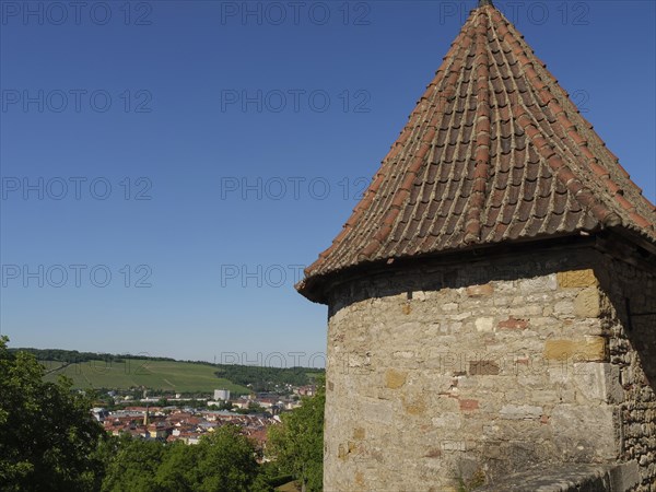 Historic stone tower and wall with a view of the village and surrounding vineyards in the sunshine, Würzburg, Bavaria, Germany, Europe