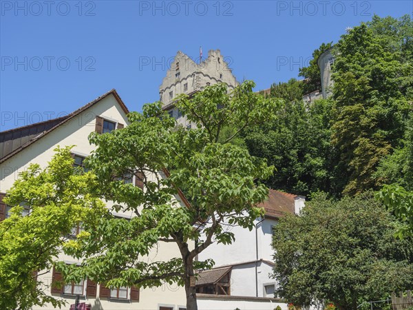 View of a medieval castle on a hill with trees and houses in the foreground on a sunny day, Meersburg, Lake Constance, Germany, Europe