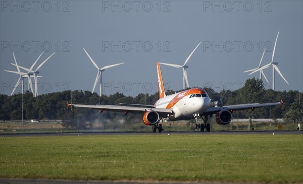 Easyjet aircraft landing at Amsterdam Schiphol Airport, Polderbaan, 18R/36L, wind farm in the background, Netherlands