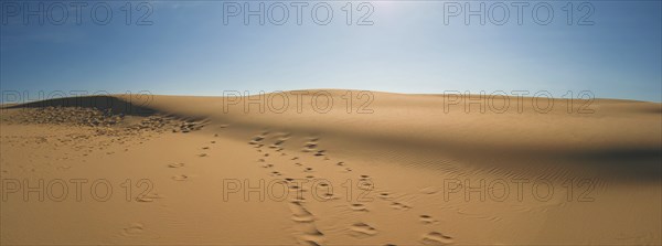 Sand dunes with blue sky and sun