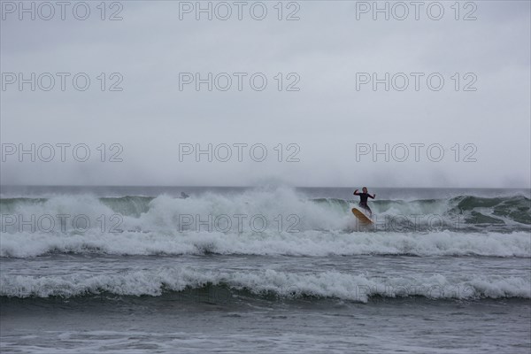 A surfer enjoying the waves on a windy day in the North-West. Strandhill, Sligo, Ireland, Europe