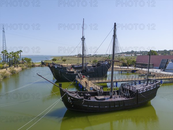 Resting harbour with historical replicas of sailing ships in the water under a clear sky, aerial view, Muelle de las Carabelas, reproductions of La Nina, La Pinta and La Santa Maria, Museum, Palos de la Frontera, Province of Huelva, Andalusia, Spain, Europe