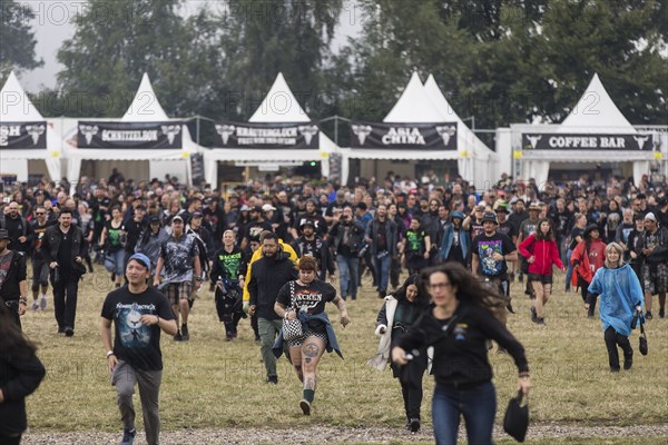 Festival visitors storm onto the infield at the Wacken Open Air in Wacken immediately after opening. The traditional metal festival takes place from 31 July to 3 August 2024