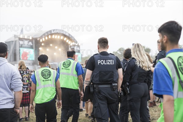 Police officers and metal guards in front of the Louder stage at the Wacken Open Air in Wacken. The traditional metal festival will take place from 31 July to 2 August 2024