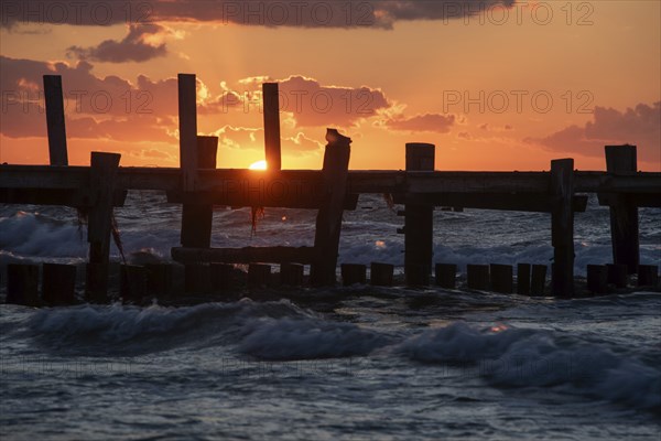 Sunset at the Baltic Sea with an old jetty in the foreground and dark clouds in the sky, Baltic Sea peninsula Fischland-Darss-Zingst, Zingst, Mecklenburg-Vorpommern, Germany, Europe