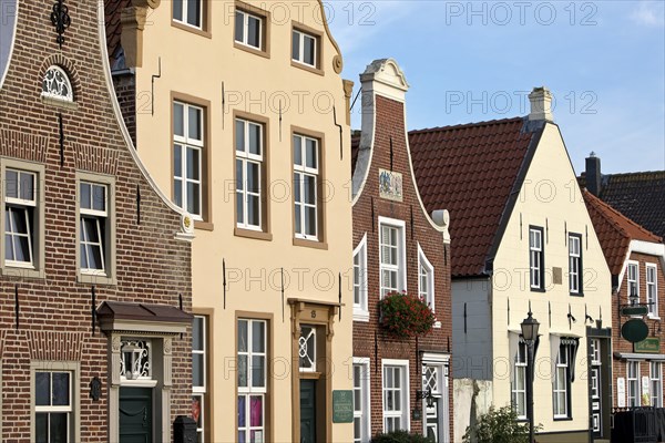 Facades of the houses at the fishing harbour, Greetsiel, Krummhörn, East Frisia, Lower Saxony, Germany, Europe