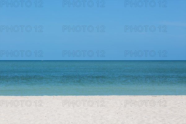 Sandy beach with blue sky and horizon of calm sea, Gulf of Mexico coast, Celestun, Yucatan, Mexico, Central America