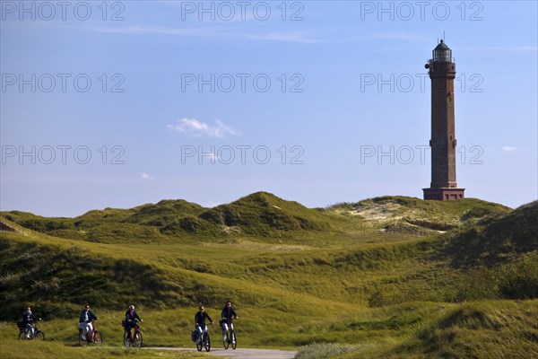Large Norderney lighthouse in the dune landscape with cyclists, Norderney Island, East Frisia, Lower Saxony, Germany, Europe