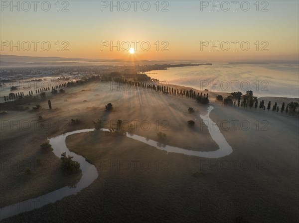 Aerial view of the Radolfzeller Aach at sunrise, which leads through the foggy Radolfzeller Aachried, on the right the western part of Lake Constance, on the left the town of Radolfzell, district of Constance, Baden-Württemberg, Germany, Europe