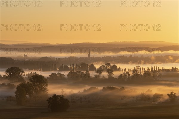 Early morning fog with sunrise over the Radolfzeller Aachried, behind it Lake Constance with the town of Radolfzell, district of Constance, Baden-Württemberg, Germany, Europe