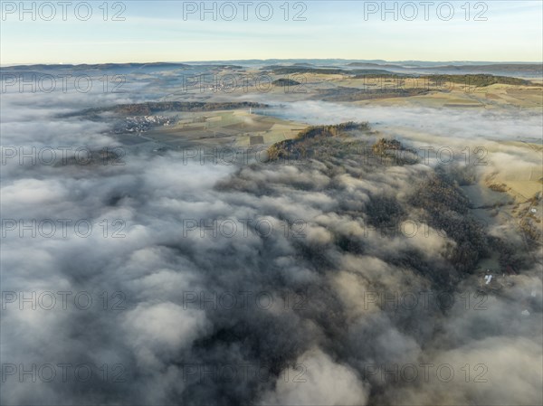 Aerial view of the wintry and fog-covered Hegaulandschaft shortly after sunrise, on the horizon the mountain range Alter Postweg near Leipferdingen, district of Constance, Baden-Württemberg, Germany, Europe