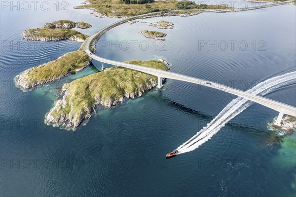 Aerial view of bridge connecting islands at the norwegian coast, motor boat passing below the bridge, Norway, Europe