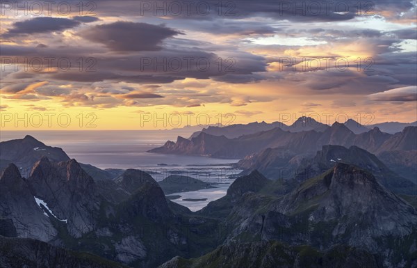 View over mountain top and sea to Fredvang, dramatic sunset, from the top of Hermannsdalstinden, Moskenesöy, Lofoten, Nordland, Norway, Europe