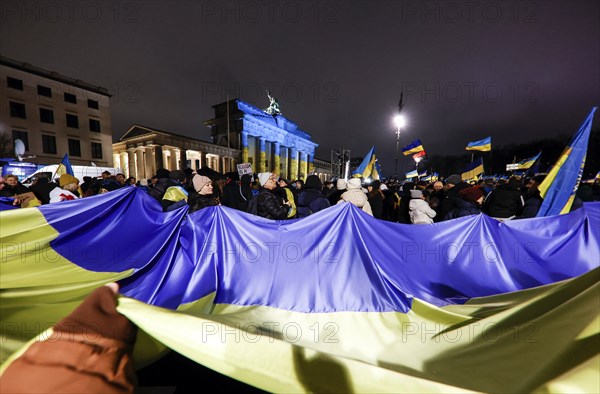 People demonstrate with a huge Ukrainian flag at the Brandenburg Gate on the anniversary of the Russian war of aggression against Ukraine, Berlin, 24 February 2023