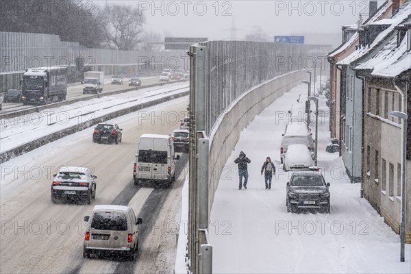A40 motorway, onset of winter, lots of fresh snow and daytime temperatures below minus 5 degrees, uncleared carriageway, little traffic, poor road conditions, noise barrier, quiet residential road, at the Essen-Ost motorway junction, Essen, North Rhine-Westphalia, Germany, Europe