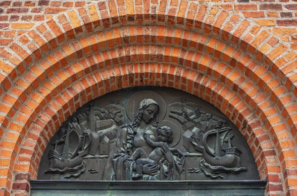 Relief image depicting Mary with the child under brick arches and above the entrance to the Church of Mary in Ystad, Skane County, Sweden, Scandinavia, Europe