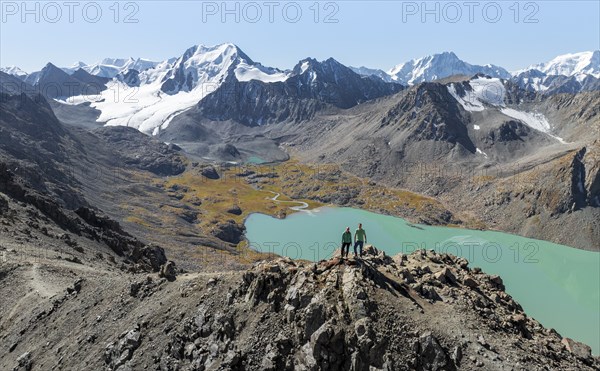 Hiker at the pass at 4000m, aerial view, mountains with glacier, mountain pass and mountain lake Ala-Kul Lake, Tien Shan, Kyrgyzstan, Asia