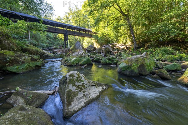 The Irrel Waterfalls, rapids in the lower reaches of the Prüm, covered wooden bridge for hikers, between Prümzurlay and Irrel, in the Eifel district of Bitburg-Prüm, Rhineland-Palatinate. Germany