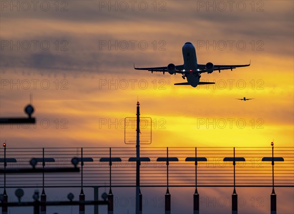 Runway lighting, approach aids, at Düsseldorf International Airport, sunset, aircraft taking off and approaching the southern main runway, 05R/23L, North Rhine-Westphalia, Germany, Europe