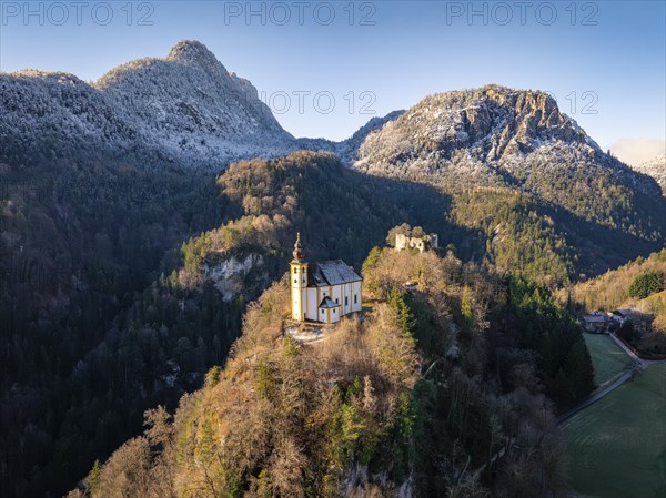 A church on a hill with a view of a castle ruin and wooded mountains in the morning light, St Pankraz, Karlstein, Bad Reichenhall, Germany, Europe