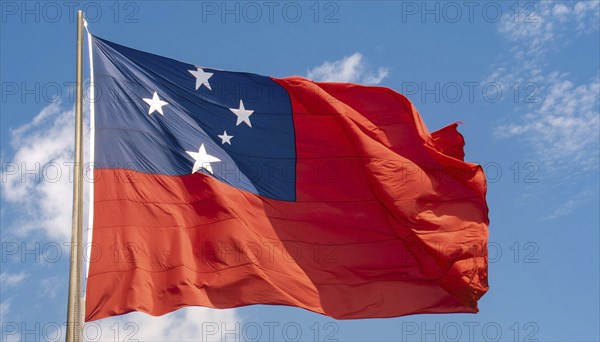 The flag of Samoa, fluttering in the wind, isolated against a blue sky