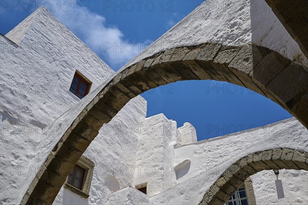View upwards of arches and white walls against a blue sky, part of a historic monastery, Inside the monastery, Agiou Theologou Monastery, Chora, Patmos, Dodecanese, Greek Islands, Greece, Europe