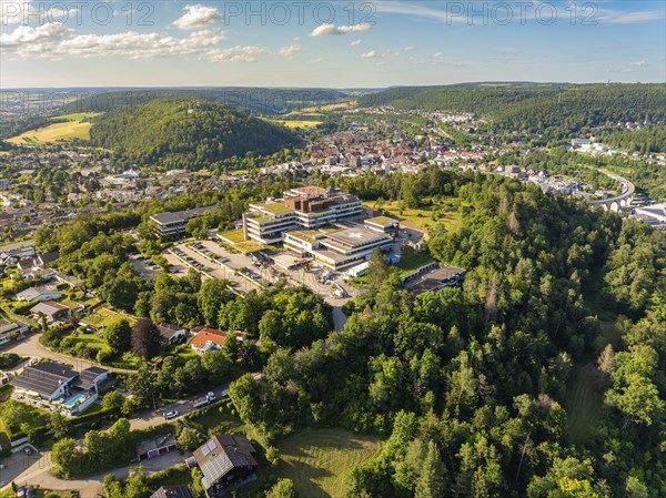 Aerial view of a town in green surroundings, many houses and a large building on a hill, blue summer sky, hospital, Nagold, Black Forest, Germany, Europe