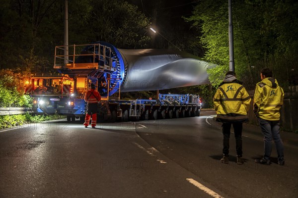 Transport of a 68 metre long, 22 tonne blade of a wind turbine, here in Schwelm, with a self-propelled Blade-Lifter vehicle, over a 40 km long route, over 2 nights, in the Bergisches Land, through towns, villages, over country roads, narrow through roads, to the construction site of the wind turbine near Hagen, North Rhine-Westphalia, Germany, Europe