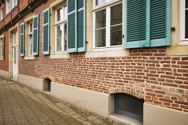 Windows with blue-green shutters on a brick house in Warendorf, Warendorf district, North Rhine-Westphalia, Germany, Europe
