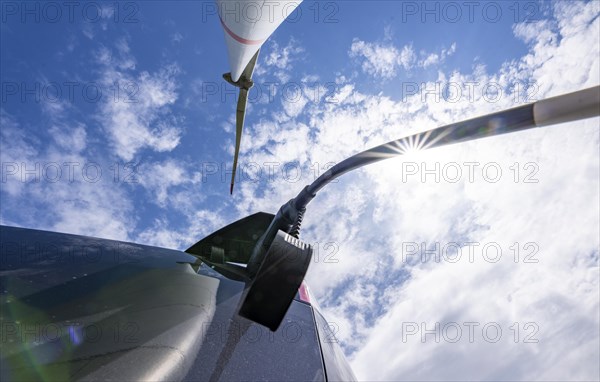 Wind turbine, technician charging his electric car during wind turbine maintenance, directly at the turbine, North Rhine-Westphalia, Germany, Europe