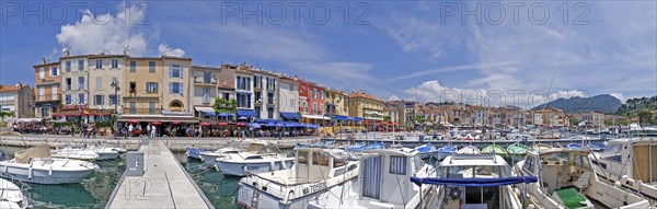 A picturesque harbour with numerous boats, colourful buildings and restaurants under a blue sky with clouds, Cassis, Provence, Provence-Alpes-Cote d'Azur, South of France, France, Europe