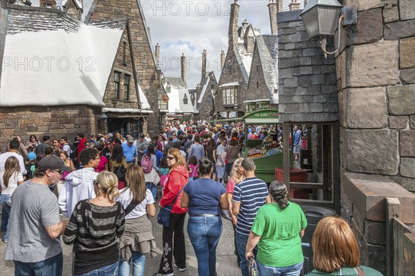 Theme park guests walk through Hogsmeade in The Wizarding World of Harry Potter at Universal Studios, Orlando, Florida, USA, North America